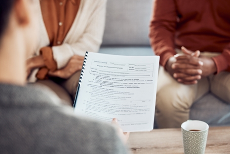 a couple being handed a divorce form while sitting on a couch