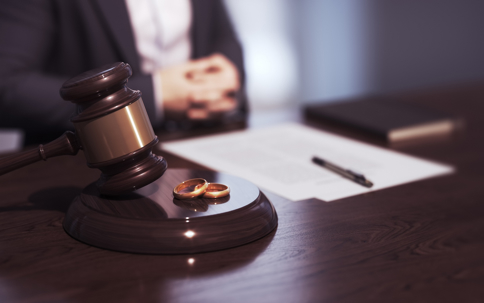 wedding rings on a lawyer's desk next to a gavel